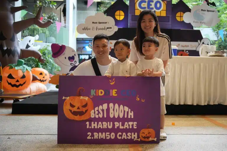 A family holding the Best Booth award board