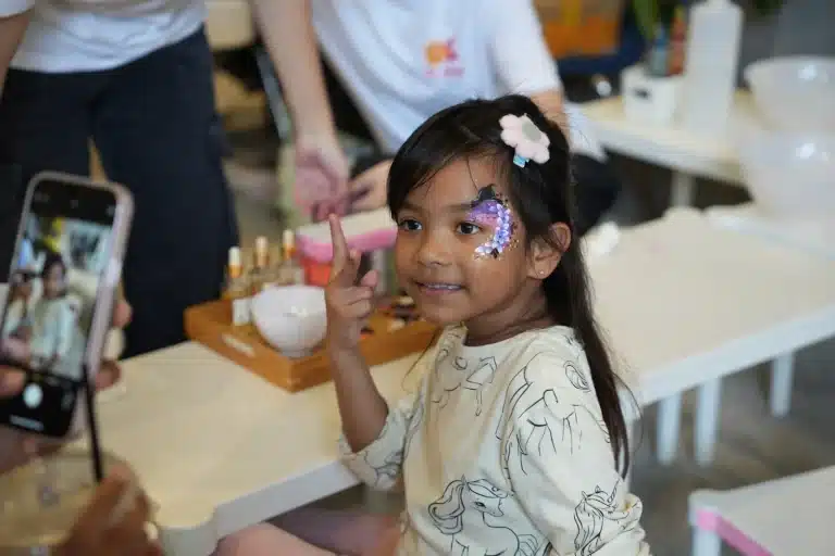 A girl with Halloween face paint smiling at the camera